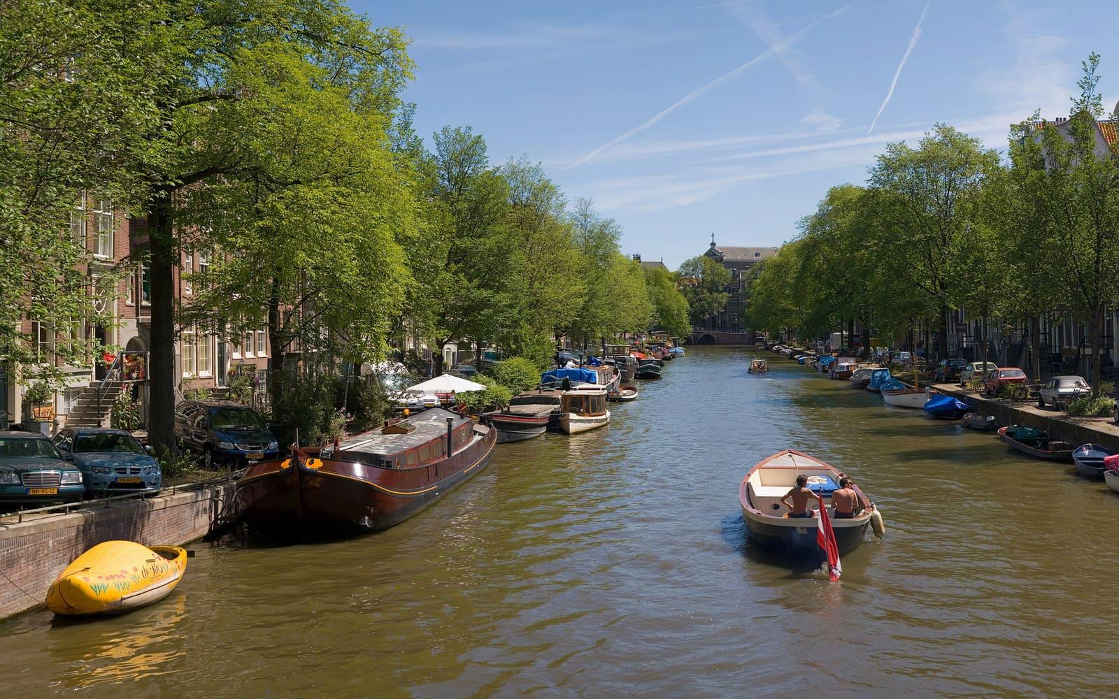 Canal de Ámsterdam con barcos y casas tradicionales
